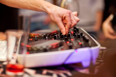 DJ gece kulübünde konsolda müzik karıştırıyor.