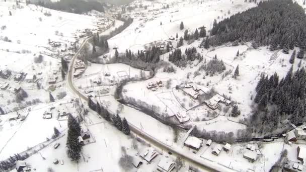 Tiro aéreo da estrada coberta de neve nas montanhas dos Cárpatos do campo — Vídeo de Stock