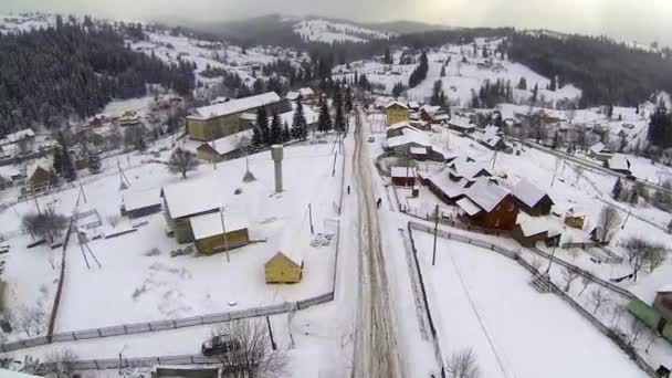 Luchtfoto van dorp in de Karpaten op wintertijd — Stockvideo