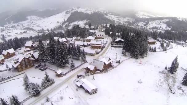 Luchtfoto van dorp in de Karpaten op wintertijd — Stockvideo