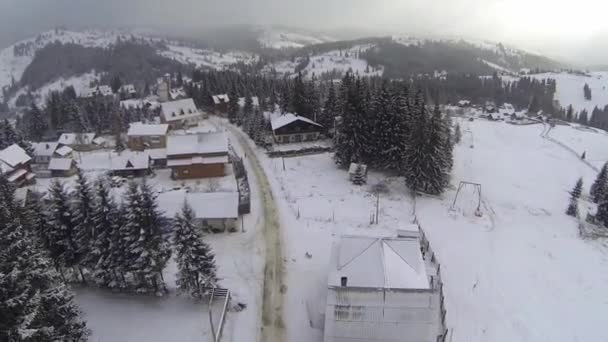 Luchtfoto van dorp in de Karpaten op wintertijd — Stockvideo