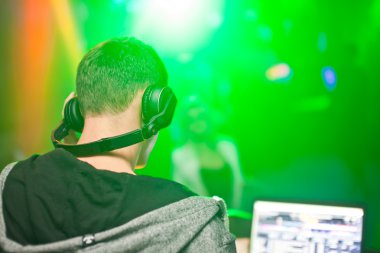 DJ gece kulübünde konsolda müzik karıştırıyor.