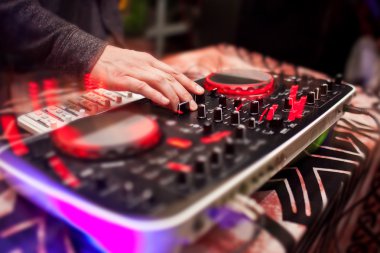 DJ gece kulübünde konsolda müzik karıştırıyor.