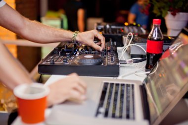 DJ gece kulübünde konsolda müzik karıştırıyor.