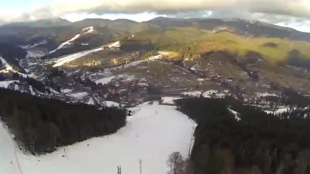 Tiro aéreo de estância de esqui Bukovel com encostas cobertas de neve na primavera — Vídeo de Stock