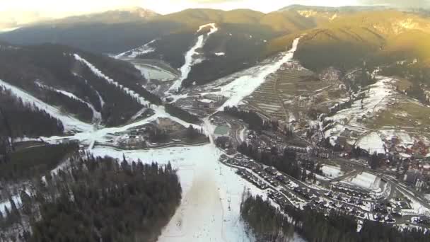 Antenn skott av skidorten Bukovel med snö täckta sluttningarna på våren — Stockvideo