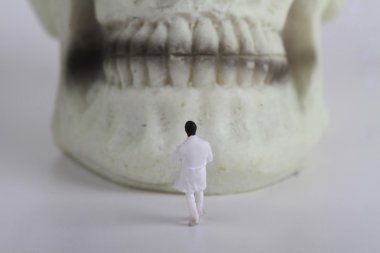 Dişlerin önündeki minyatür bir dişçi figürü
