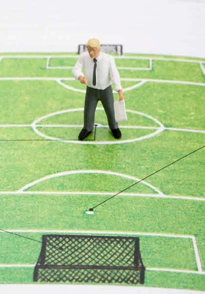 Miniaturní soška fotbalový trenér učí zelený fotbalové hřiště — Stock fotografie