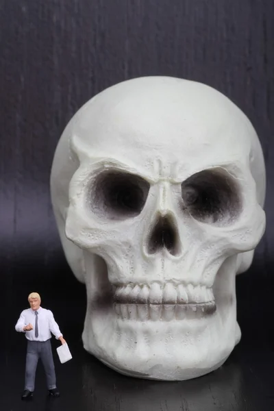 Estatueta miniatura de um professor de anatomia com um crânio humano — Fotografia de Stock