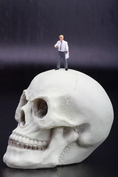 Figurine miniature d'un professeur d'anatomie avec un crâne humain — Photo