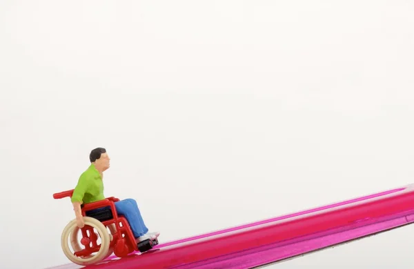 Miniatura de um homem com deficiência em uma cadeira de rodas — Fotografia de Stock