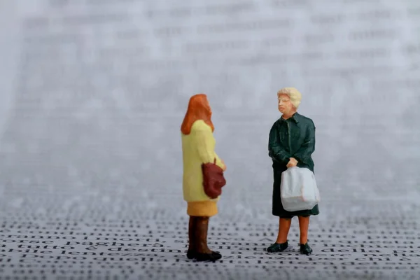 Miniatury kobiety plotkują na gazecie — Zdjęcie stockowe