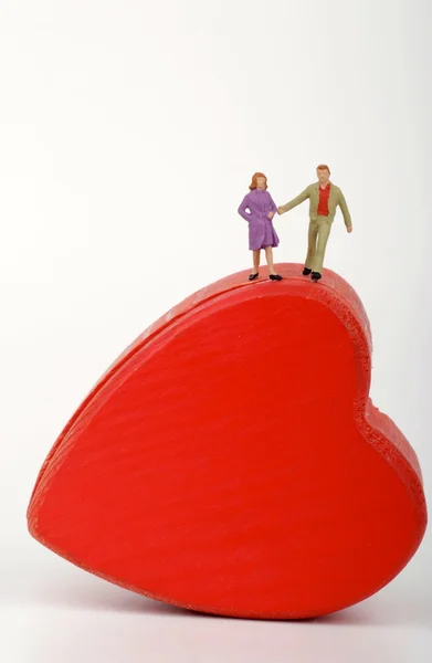 Miniature of a couple of lovers into an heart-shaped box — Stock Photo, Image