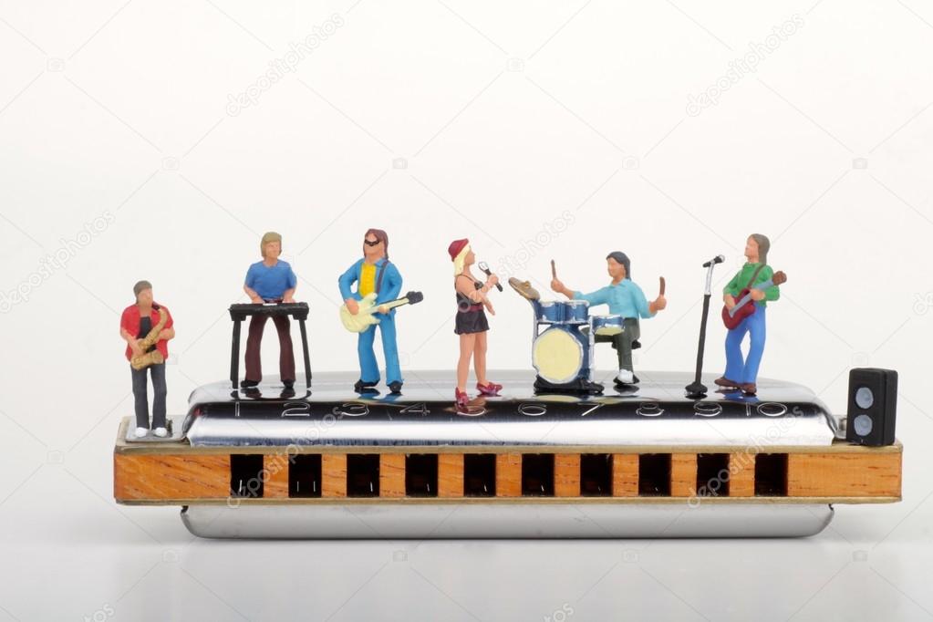 Miniature of a rock band performing on a big harmonica