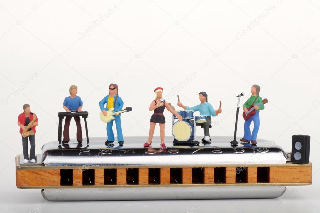 Miniature of a rock band performing on a big harmonica
