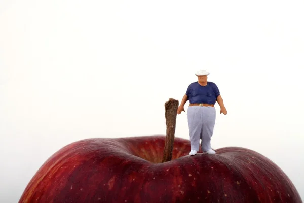 Dikke man op de bovenkant van een rode Apple - obesitas concept — Stockfoto