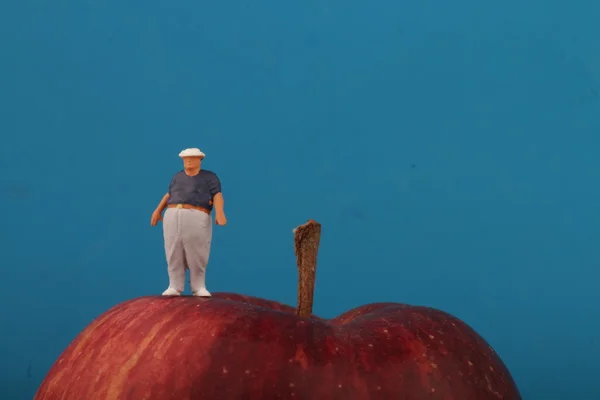 Gros homme sur le dessus d'une pomme rouge - concept d'obésité — Photo