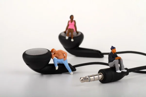 Miniatury lidí stojící na sluchátka — Stock fotografie