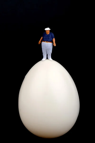 Fat man on the top of a boiled egg — Stock Photo, Image