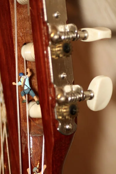 Miniaturní horolezec v akci na klasickou kytaru — Stock fotografie