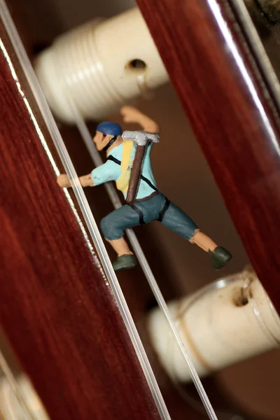Miniaturowe wspinacz w akcji na Gitare klasyczna — Zdjęcie stockowe