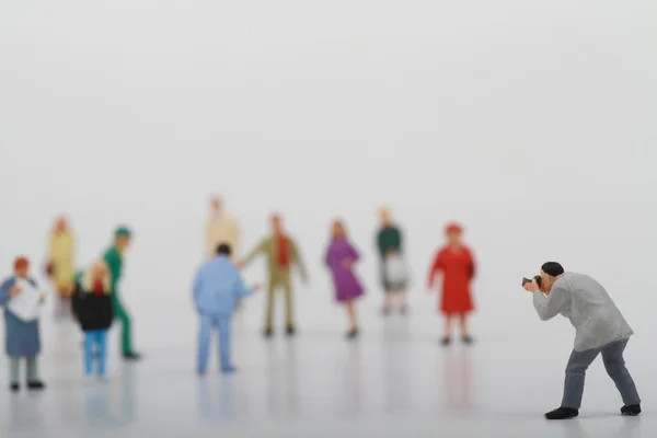 Miniatura di un fotografo di strada che scatta foto di sconosciuti che camminano su uno sfondo bianco — Foto Stock