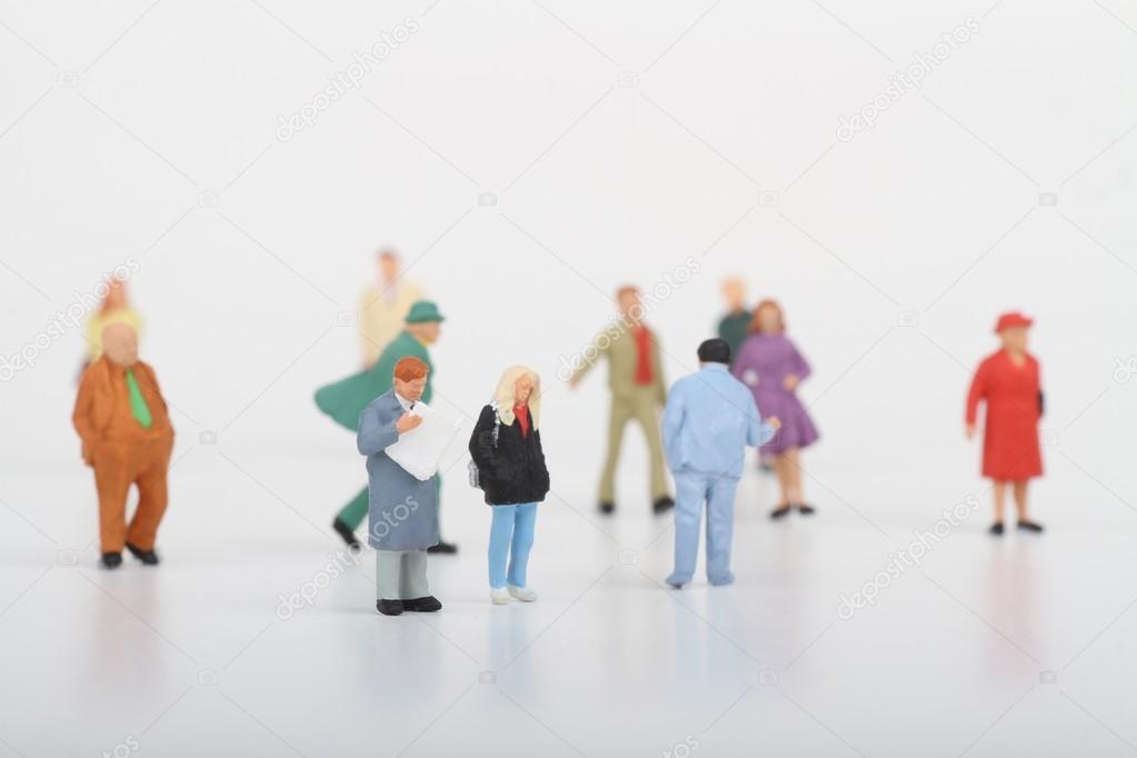 Miniatures of people walking on a white background