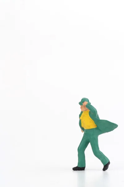 Miniaturowe eleganckiego mężczyzny, chodzenie przed wiatrem na białym tle — Zdjęcie stockowe