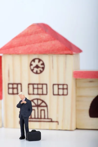 Miniature of a businessman looking at his watch while waiting for someone on a small city — Stock Photo, Image