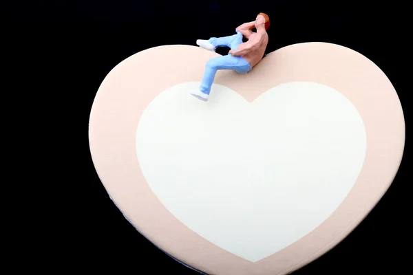 Μικρογραφία ενός ανθρώπου με φόντο ένα σχήμα καρδιάς — Φωτογραφία Αρχείου