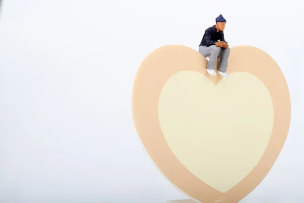 Miniature of a man with an heart shaped background — Stock Photo, Image