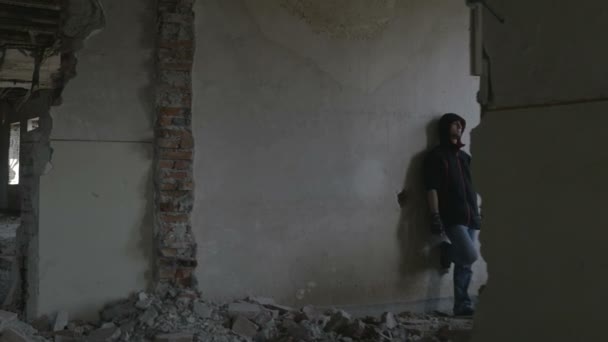 Hooded depressed young man sitting in an abandoned building — Stock Video