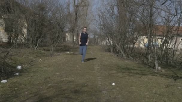 年轻运动员在被遗弃的原地慢跑 — 图库视频影像