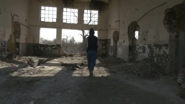 Giovane uomo incappucciato che corre in un edificio abbandonato — Video Stock