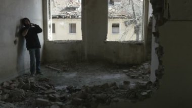 Terk edilmiş bir binada oturan kukuletalı depresif genç adam