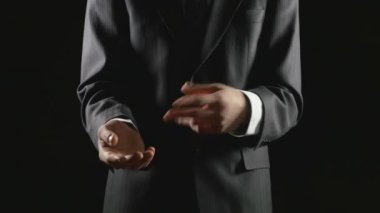 Sunulması ve siyah arka plan üzerine açıklayan genç işadamı
