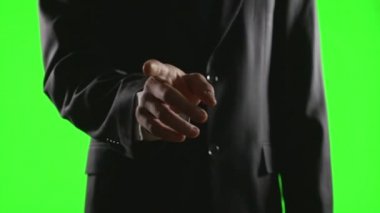 Genç işadamı yeşil ekran üzerinde bir sanal iş ortamında el hareketleri yapma