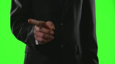 Genç işadamı yeşil ekran üzerinde bir sanal iş ortamında el hareketleri yapma