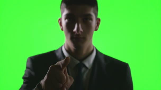 Joven hombre de negocios haciendo gestos de la mano en un entorno de negocios virtual en pantalla verde — Vídeo de stock