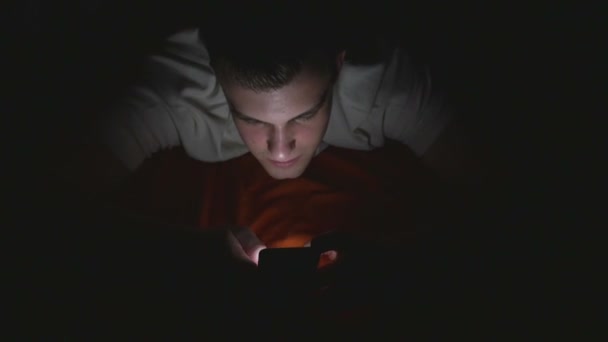Magas, szög, Kilátás, használ egy okos telefon, az ágyban vonzó fiatal ember — Stock videók