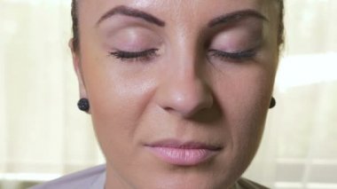 Gözlerini açarak ve gülümseyen genç çekici kadın Close-Up