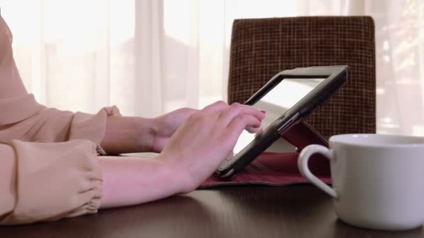 Jonge mooie zakenvrouw met tablet pc en koffie drinken — Stockvideo