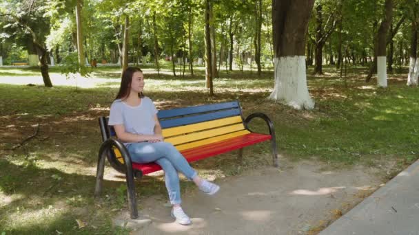 Jovem menina atraente à espera de seu amigo e receber um presente — Vídeo de Stock