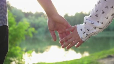 Çift holding Close-Up günbatımı ve yürüme, birlikte eller