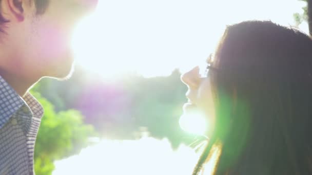 Close-up de casal amoroso beijando ao pôr do sol e olhando para o horizonte — Vídeo de Stock