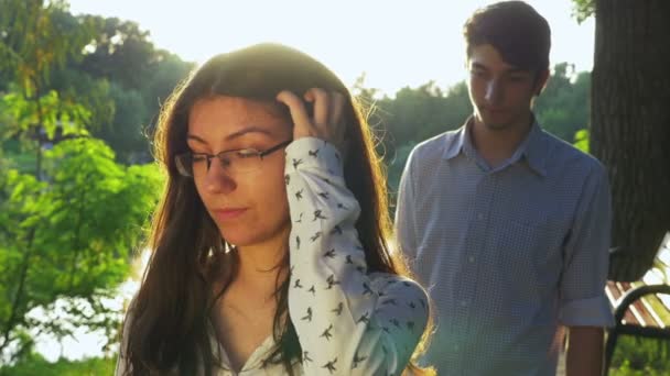 Пара чувствует себя отстраненной после драки на закате в парке — стоковое видео