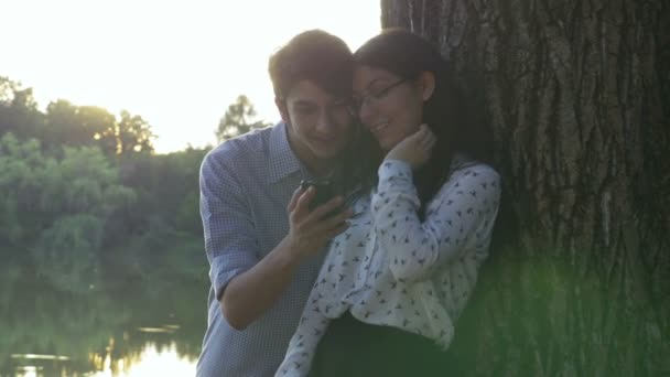 Young couple using the smartphone in the park — Stock Video