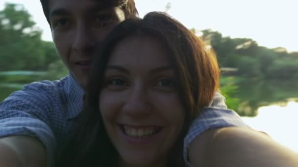 Beautiful young couple spinning in the park at sunset — Stock Video