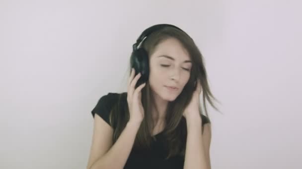Привлекательная молодая женщина слушает музыку в наушниках — стоковое видео