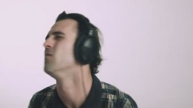 Genç adam kulaklıkla müzik dinliyor.